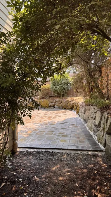 Narrow paved section between planted areas