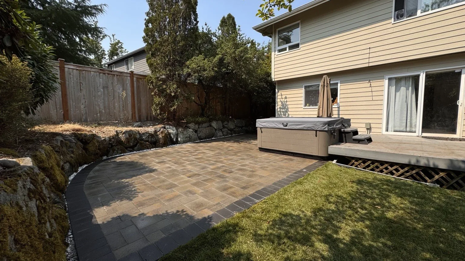 Wide view of the finished paver patio, the house and the adjoining lawn