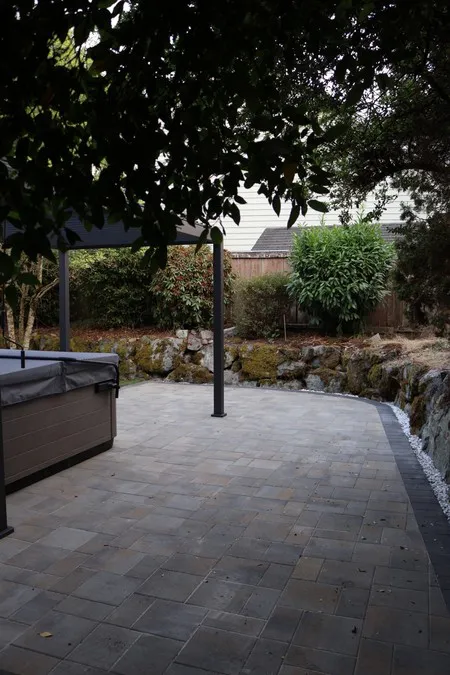 Curved patio edge beside the rock-lined planting bed